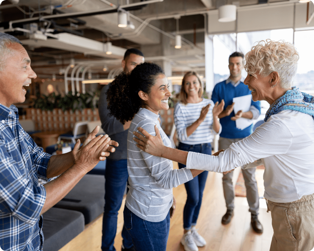 lleagues engaging in a celebration in an open office, showcasing workplace space design optimized through occupancy intelligence for social interactions and productivity.