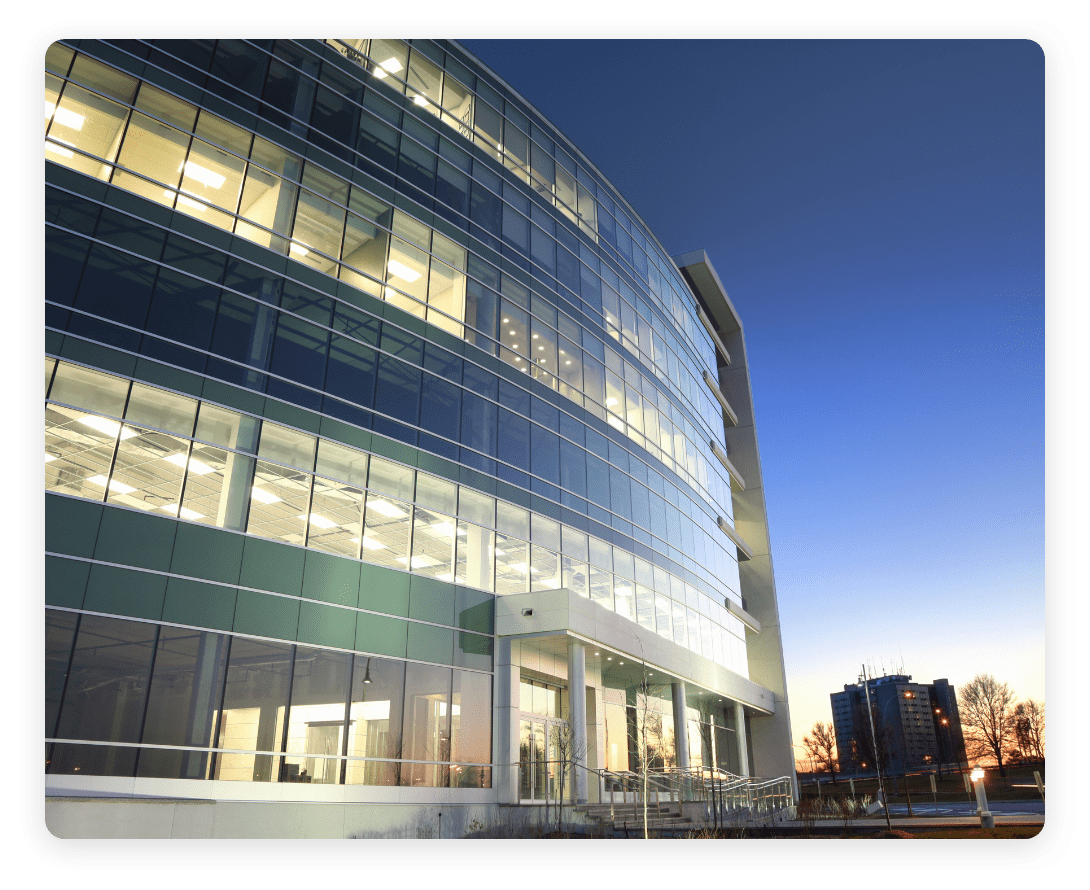 Exterior view of a modern office building at dusk, showcasing workplace architecture and space design optimized through occupancy intelligence.