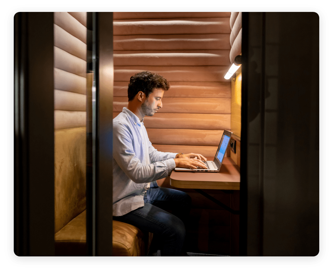 Worker using a laptop inside a private focus booth, representing optimized workplace design.